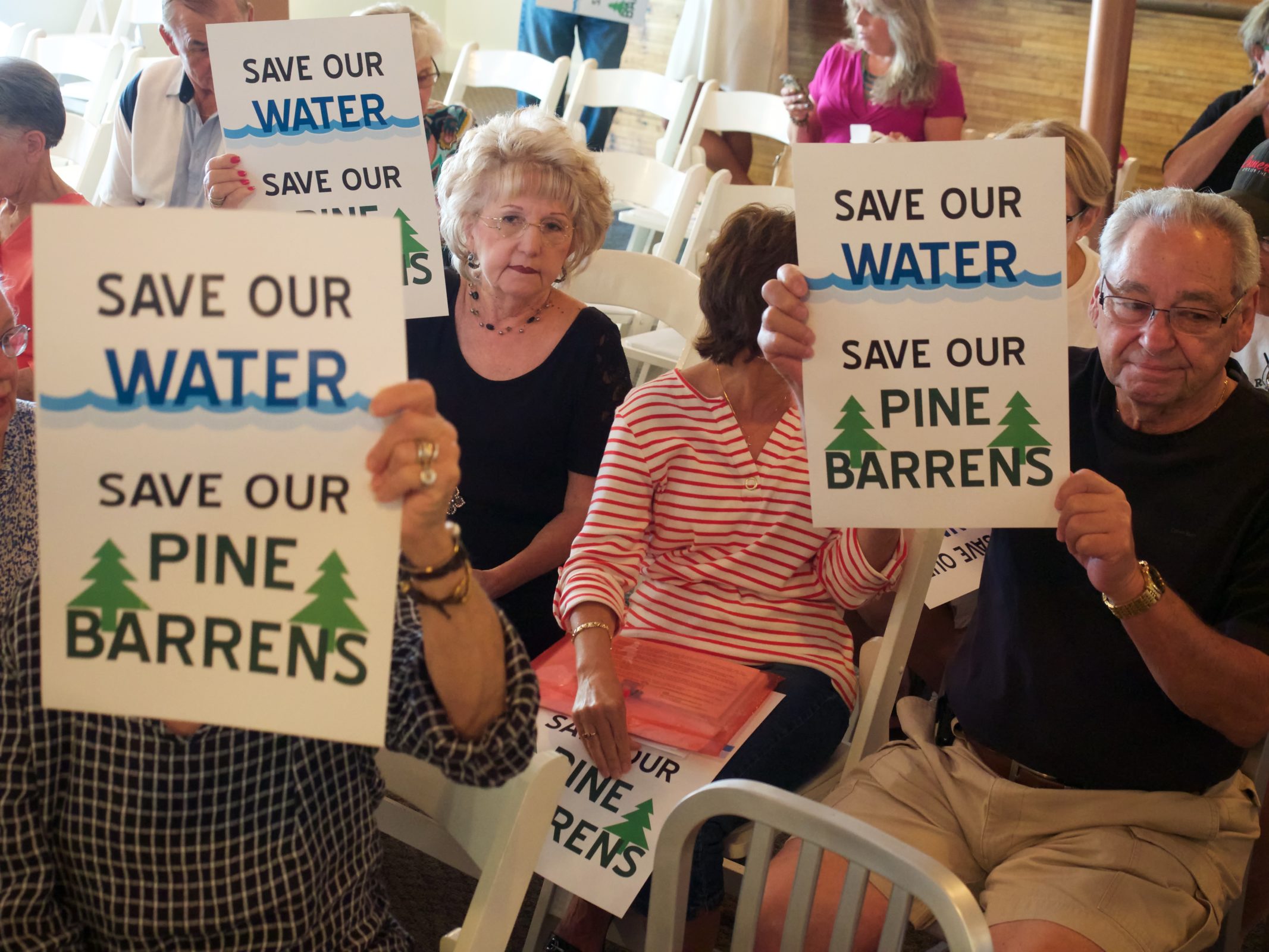 People holding signs that read save our water save our pine barrens